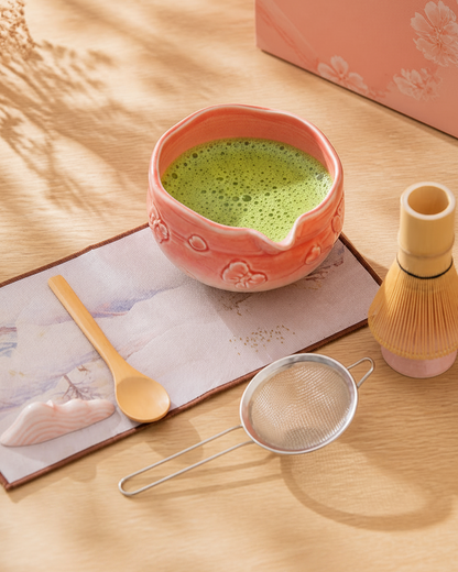Blush Bow Sakura Pink matcha bowl with whisked matcha, scoop, and sifter on a wooden table