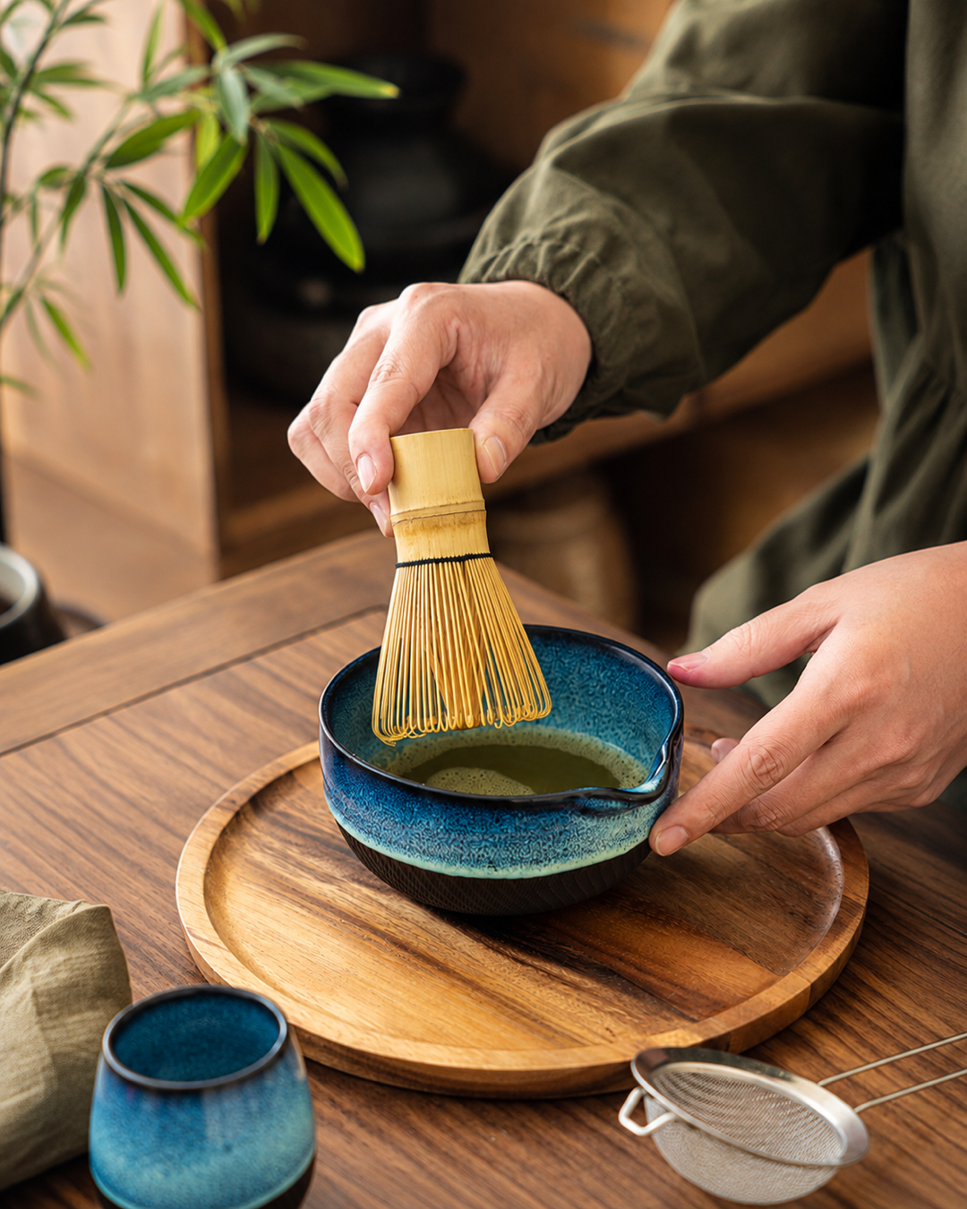 Whisking matcha in the Kiln & Ritual blue ceramic bowl
