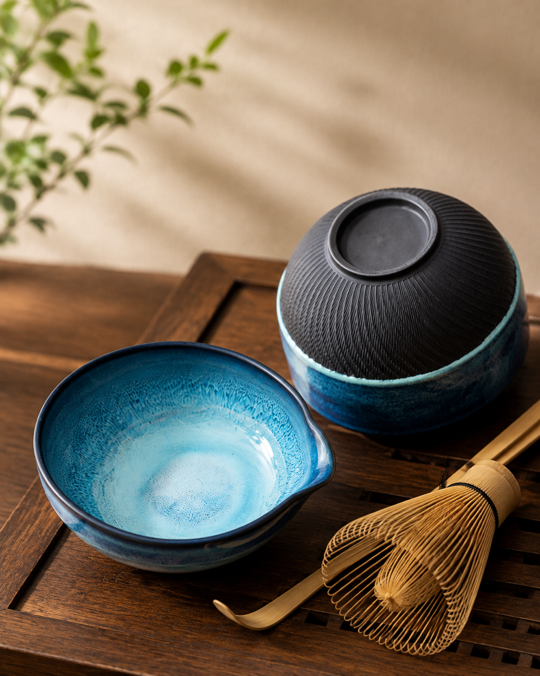 Blue ceramic matcha bowl detail with bamboo whisk and scoop