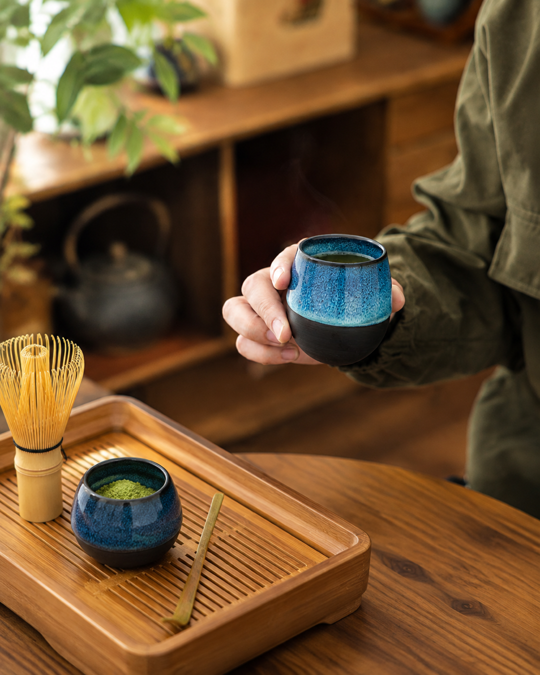 Kiln & Ritual blue ceramic cup and matcha tools on bamboo tea tray
